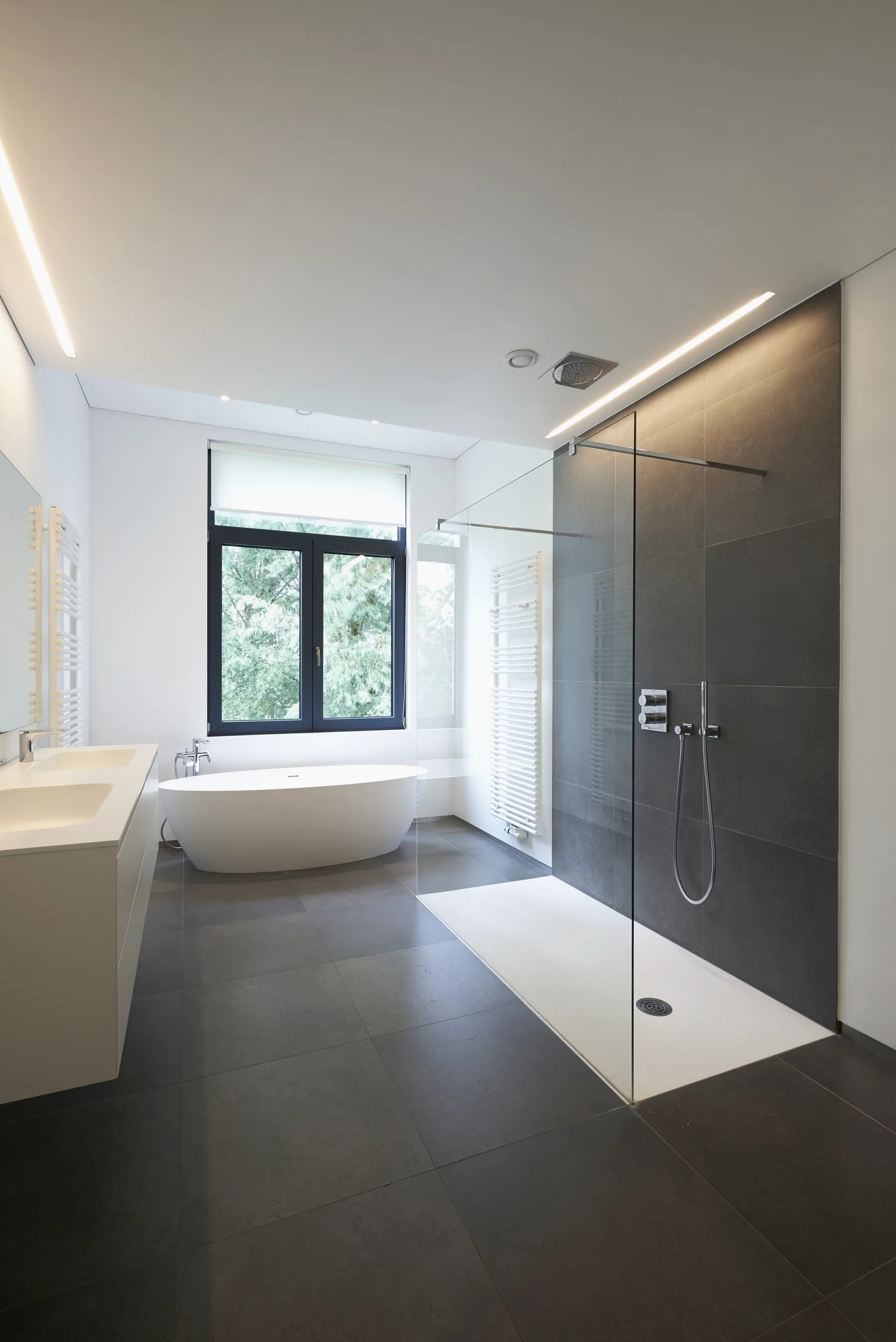 Badsanierung in Kiel: freistehende Wanne, Walk-in-Dusche und Boden in Anthrazit