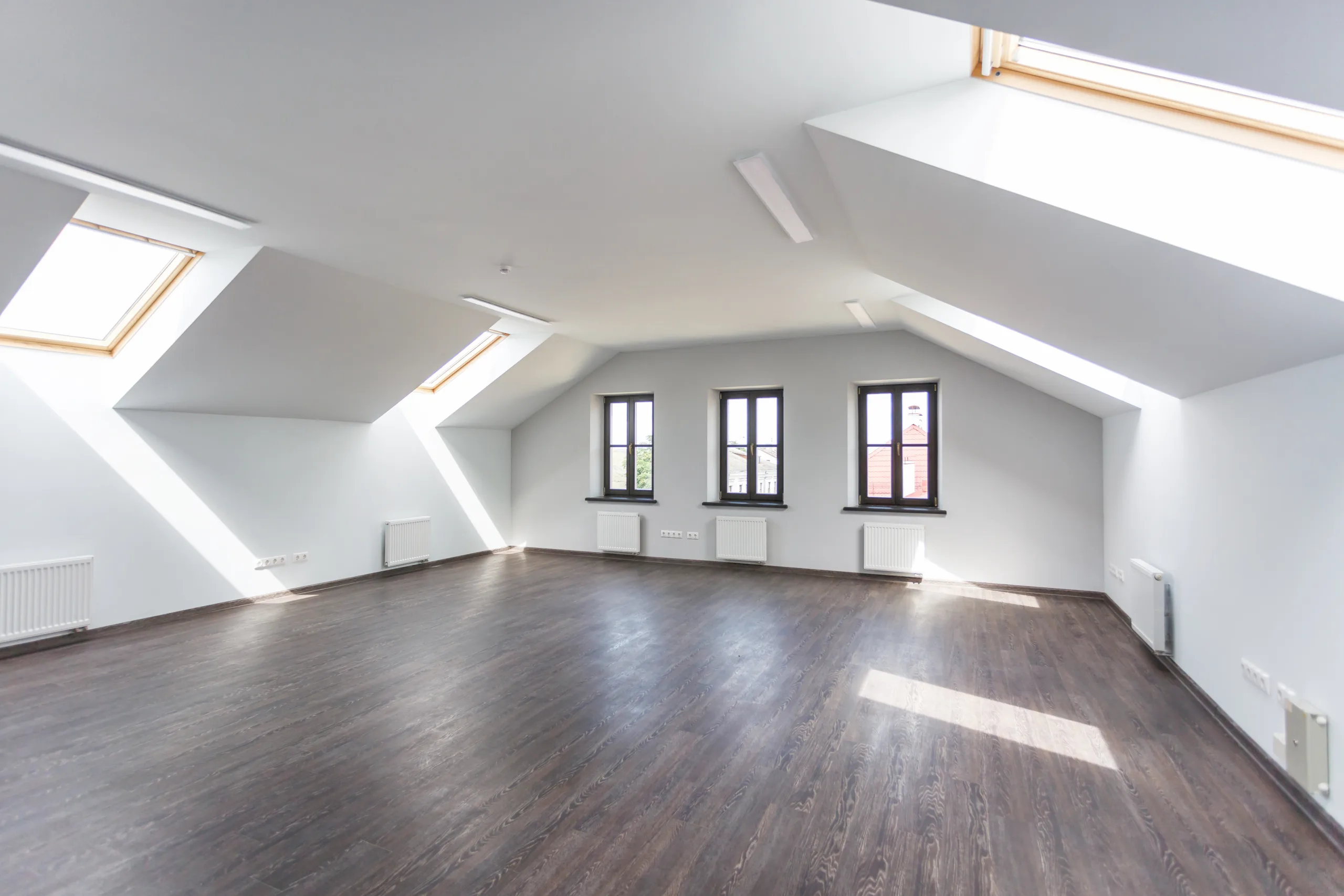 Dachgeschossausbau in Kiel: helles Dachgeschoss mit Dachfenstern und dunklem Dielenboden