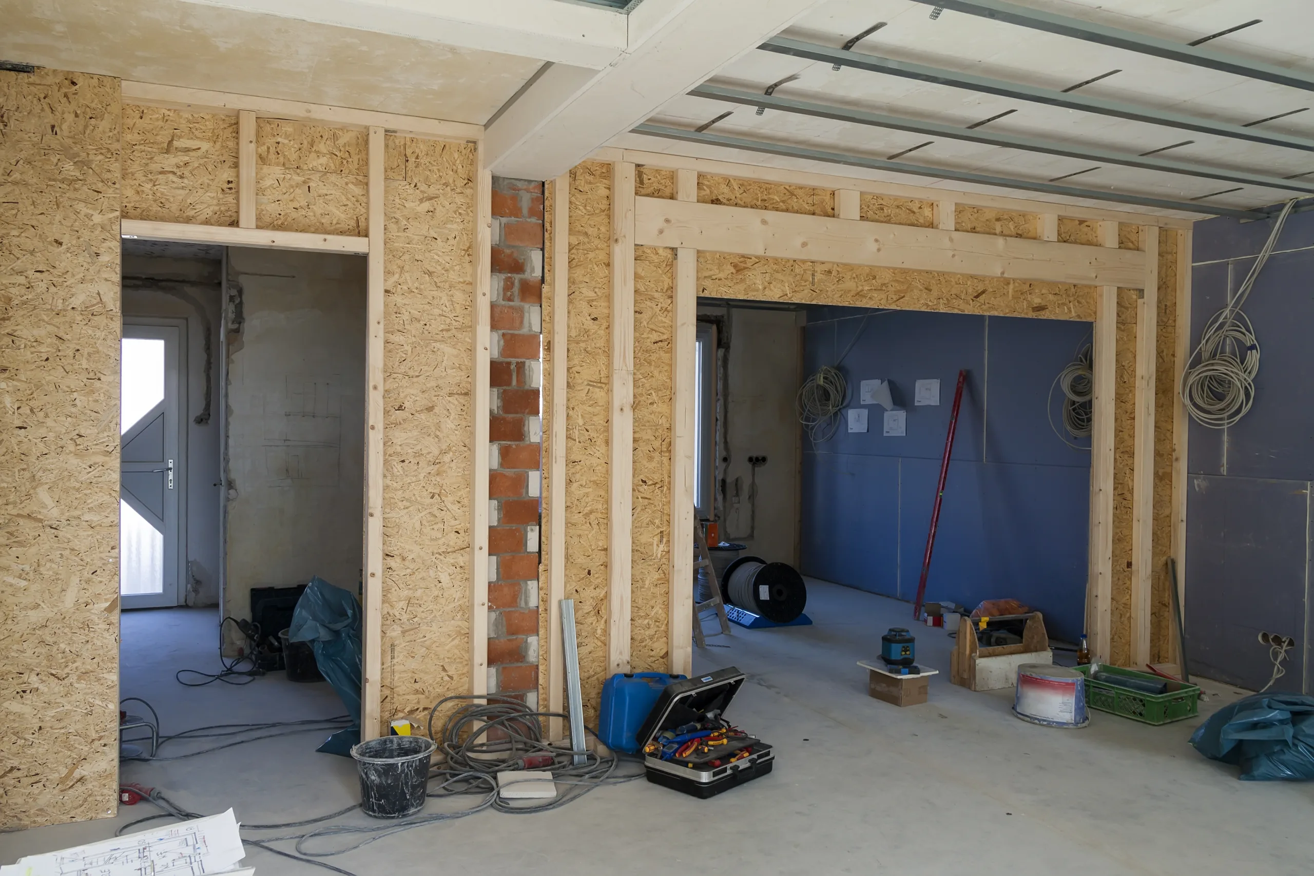 Trockenbau in Kiel: Holzst&auml;nderwand mit OSB-Beplankung und abgeh&auml;ngter Decke im Rohbau
